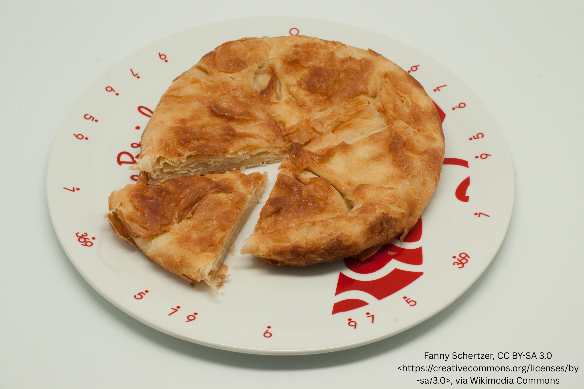 Round kouign-amann cake with a slice cut out on a plate