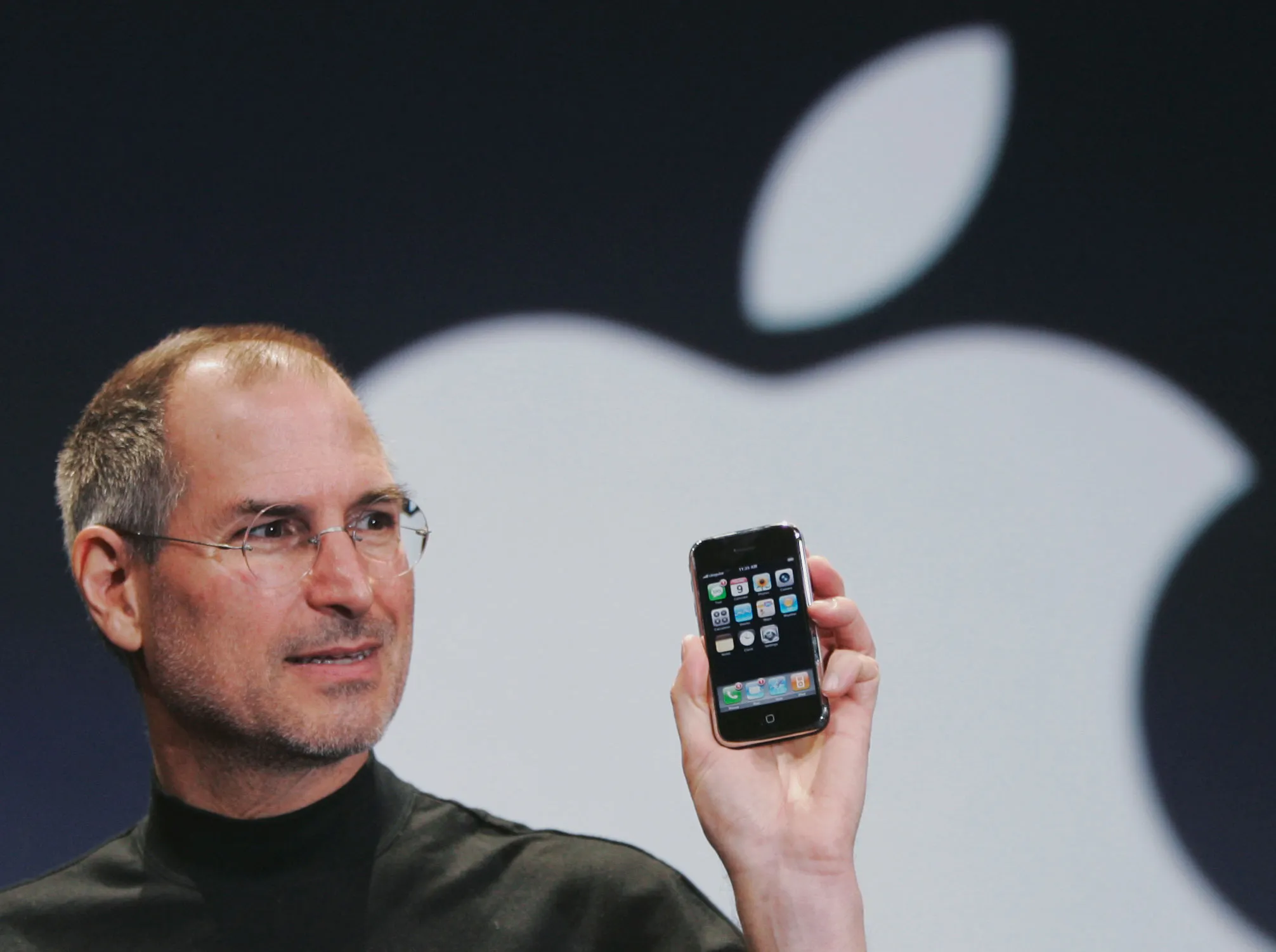 Tech visionary unveiling the first iPhone on stage with the Apple logo behind, marking a new era of human-centered design.