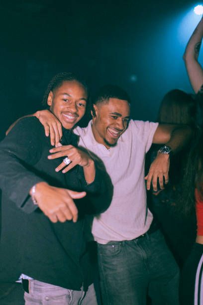 Portrait of cheerful young man dancing with male friend at nightclub