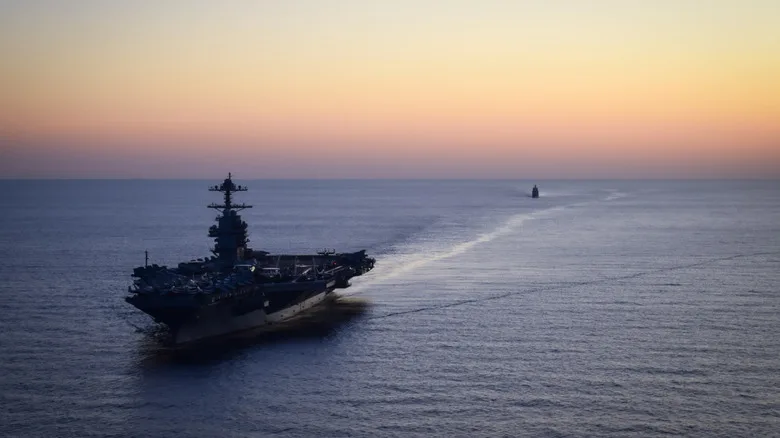 American aircraft carrier sailing away from the horizon.