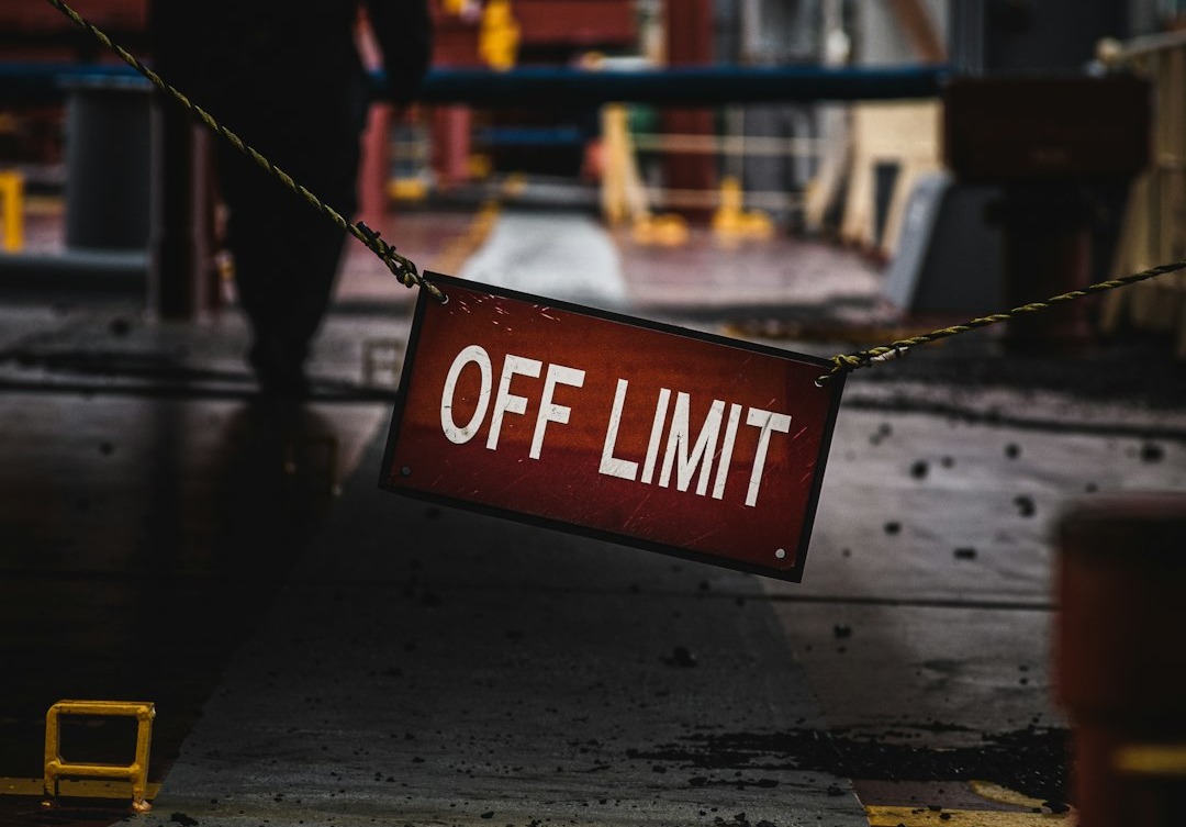 a red off limit sign hanging from a rope a red off limit sign hanging from a rope