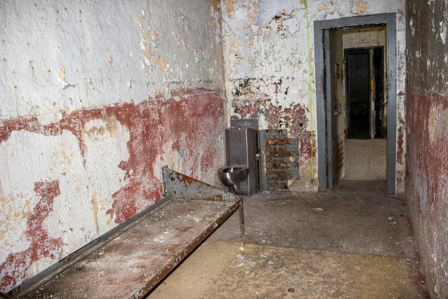 A room with a metal bench and a door