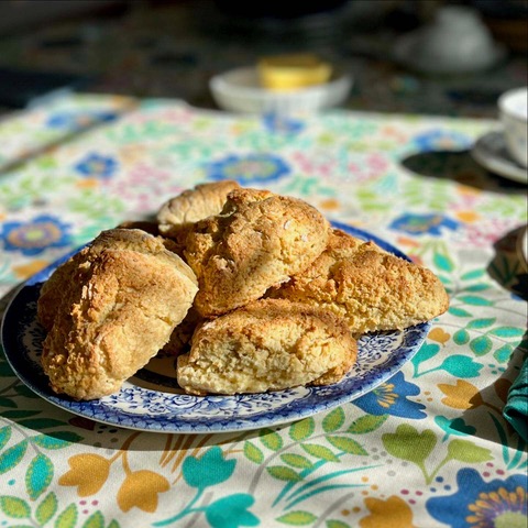 Plate of scones on a decorative table cloth.