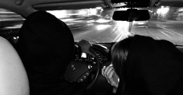 This may contain: two people driving in the back seat of a car on a highway at night time This may contain: two people driving in the back seat of a car on a highway at night time