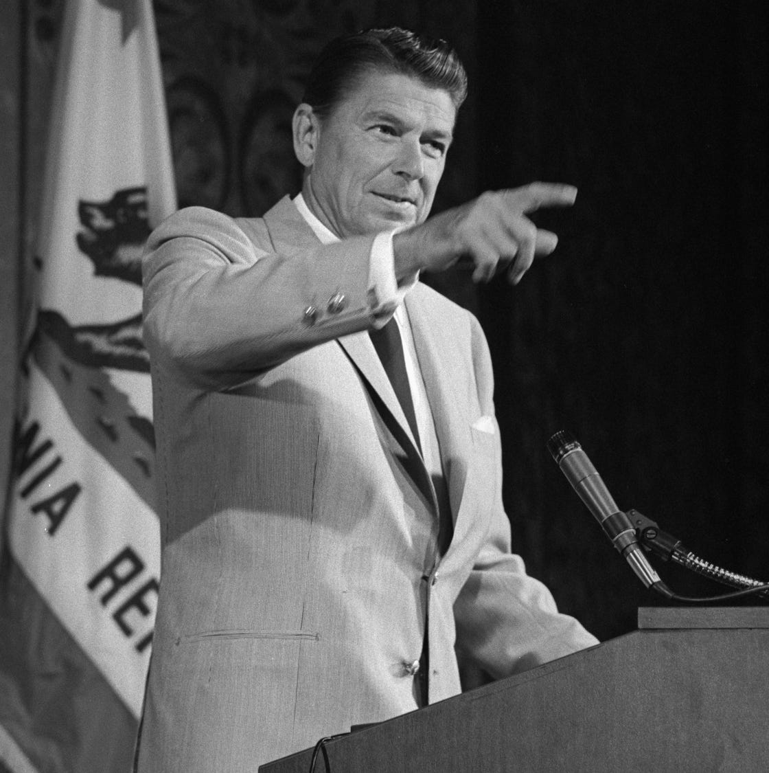Ronald Reagan, circa August 1967 ronald reagan pointing as he stands at a podium with a california flag behind him