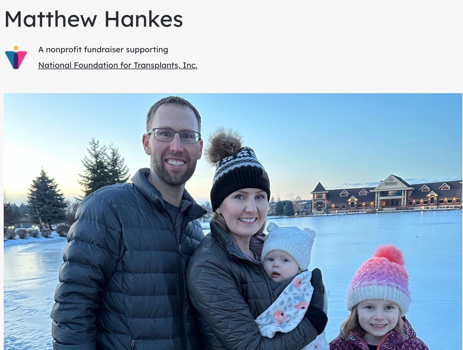 A family standing on an icy lake smiling at the camera. From Left a father, wife holding an infant, and a young daughter.