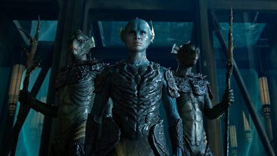 A group of blue sea creatures with human like faces stand looking fierce