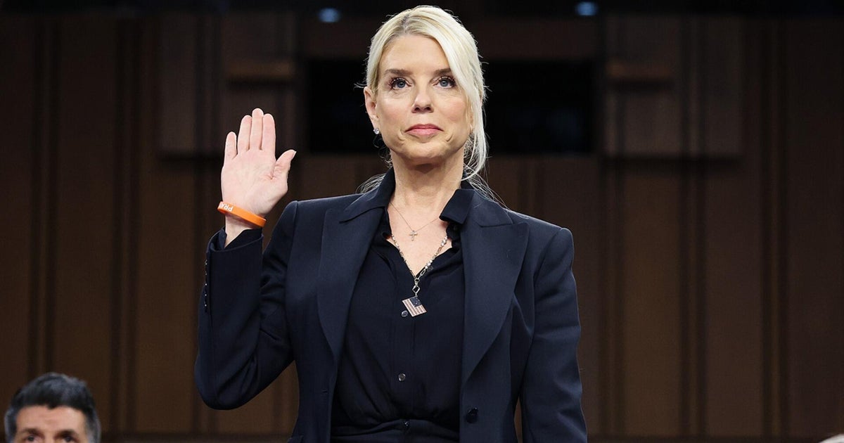 A person in a suit holding her hand up

AI-generated content may be incorrect.