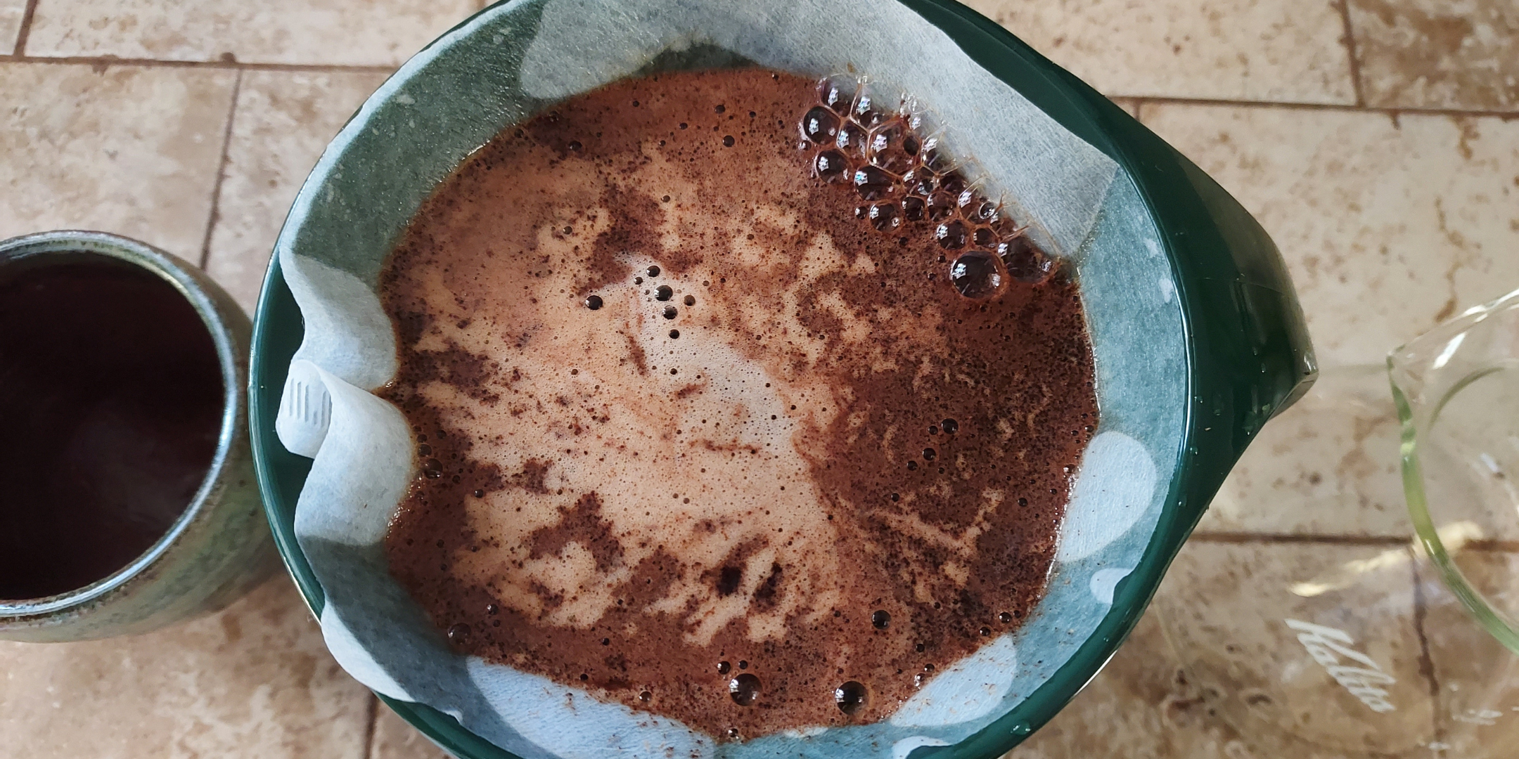 An overhead close-up of coffee brewing in a cone shaped coffee brewer.