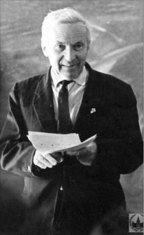 Black-and-white portrait of a white-haired man in a suit holding papers