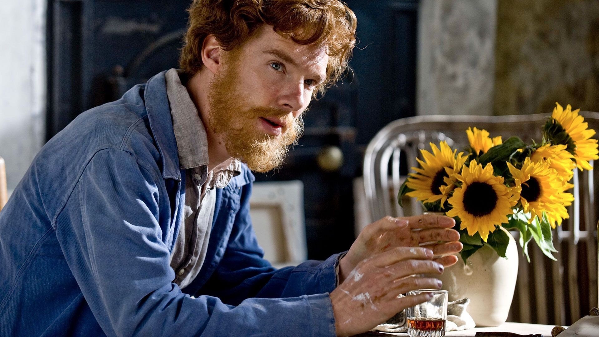 Benedict Cumberbatch portraying Van Gogh beside a vase of sunflowers