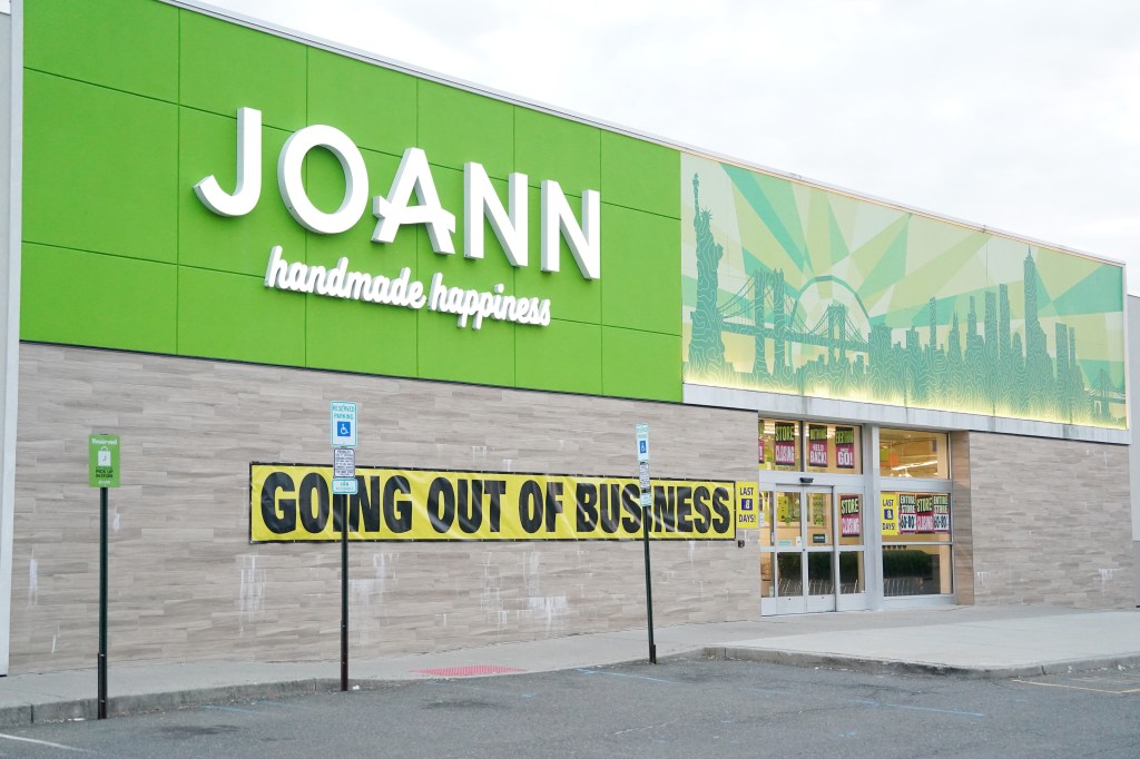 A Jo-Ann Fabrics store with a "GOING OUT OF BUSINESS" banner on its facade.