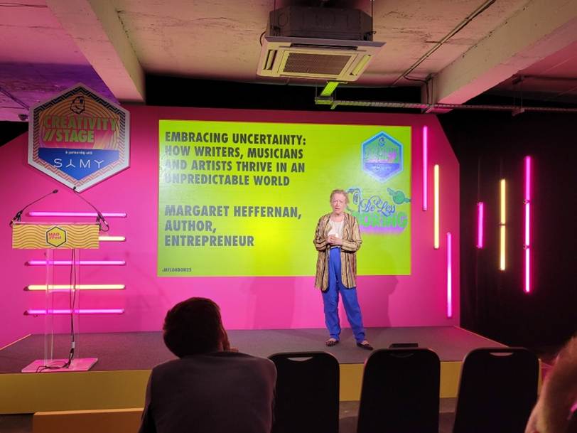 A person on stage with a large screen

AI-generated content may be incorrect.