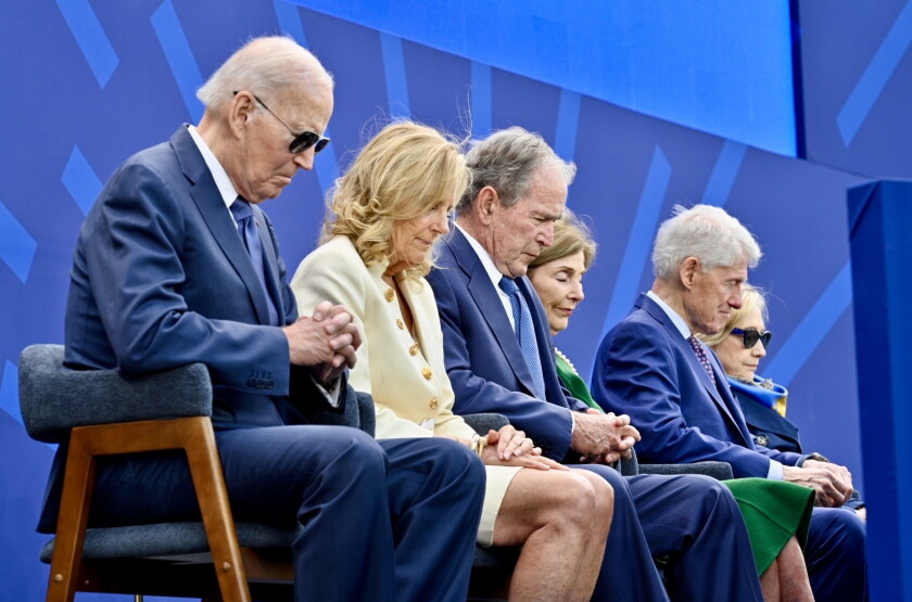 Former President Joe Biden, former first lady Jill Biden, former President George W. Bush, former first lady Laura Bush, former President Bill Clinton and former first lady Hillary Clinton bow their head in prayer.