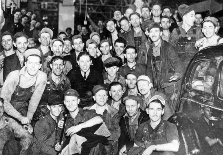 Group of 1930s industrial workers united, symbolizing the rise of labor movements and union solidarity
