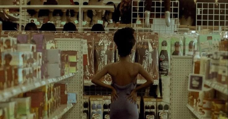This may contain: a woman is standing in the aisle of a store with her back to the camera This may contain: a woman is standing in the aisle of a store with her back to the camera