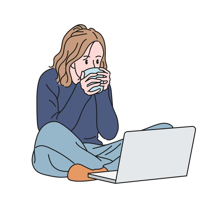 This may contain: a woman sitting on the floor drinking coffee while using her laptop