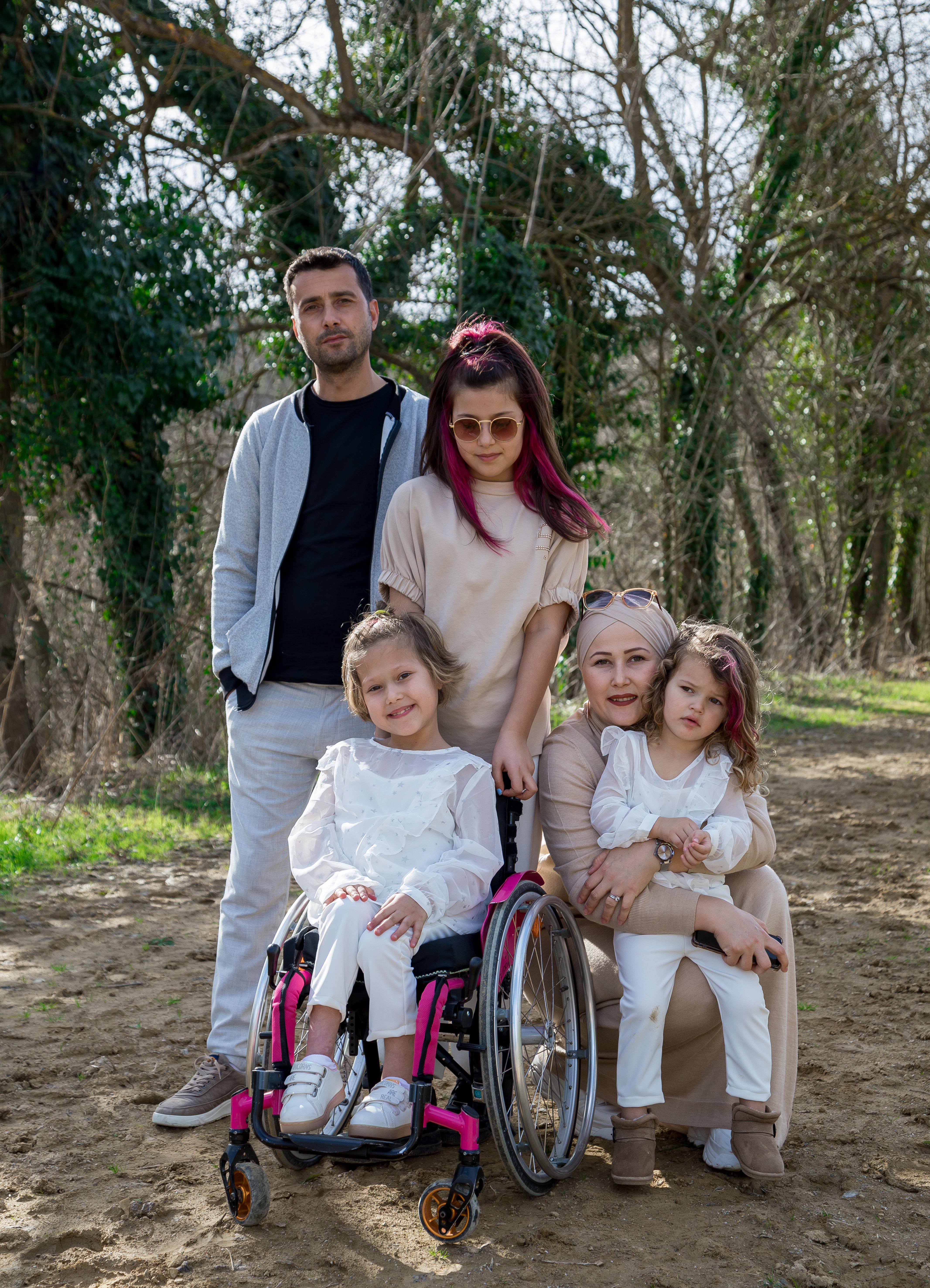 Happy family with a child in a wheelchair enjoying time together outdoors in a park