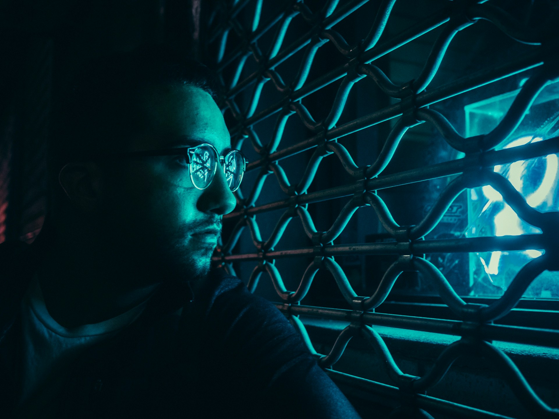 man wearing eyeglasses while looking out window