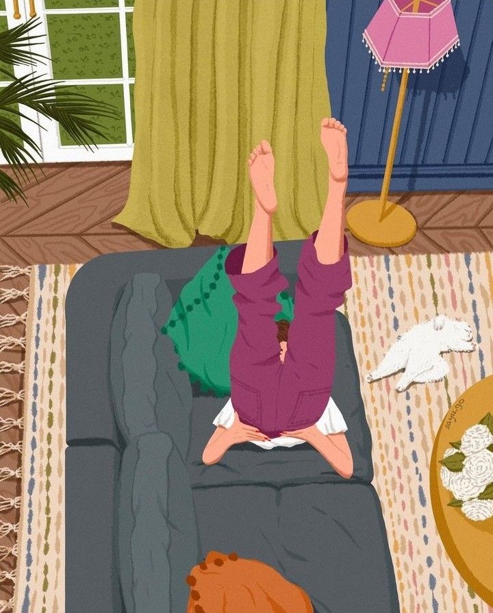 This may contain: a person sitting on a couch with their feet up in the air
