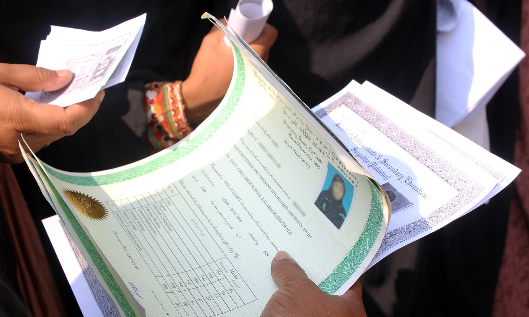A woman applicant shows the documents she has brought as supporting evidence. — Photo by author