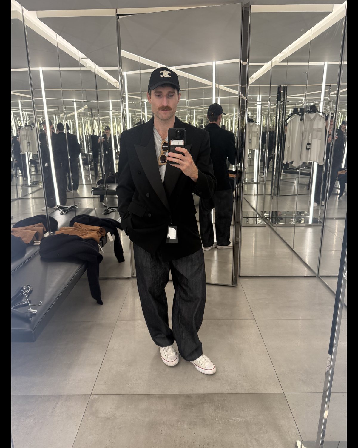Brian trying on a black Saint Laurent tuxedo jacket with wide dark trousers at the Saint Laurent outlet in San Marcos, Texas