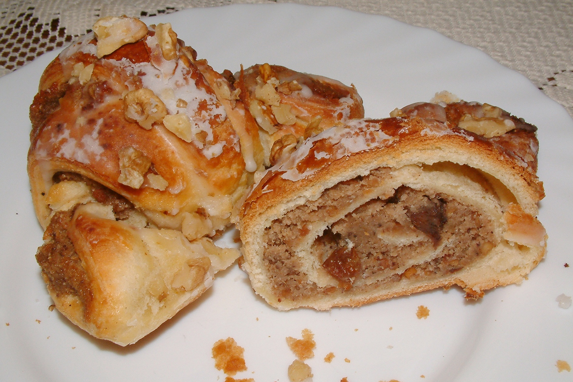 Sweet glazed crescent pastry cut open to show a nut filling