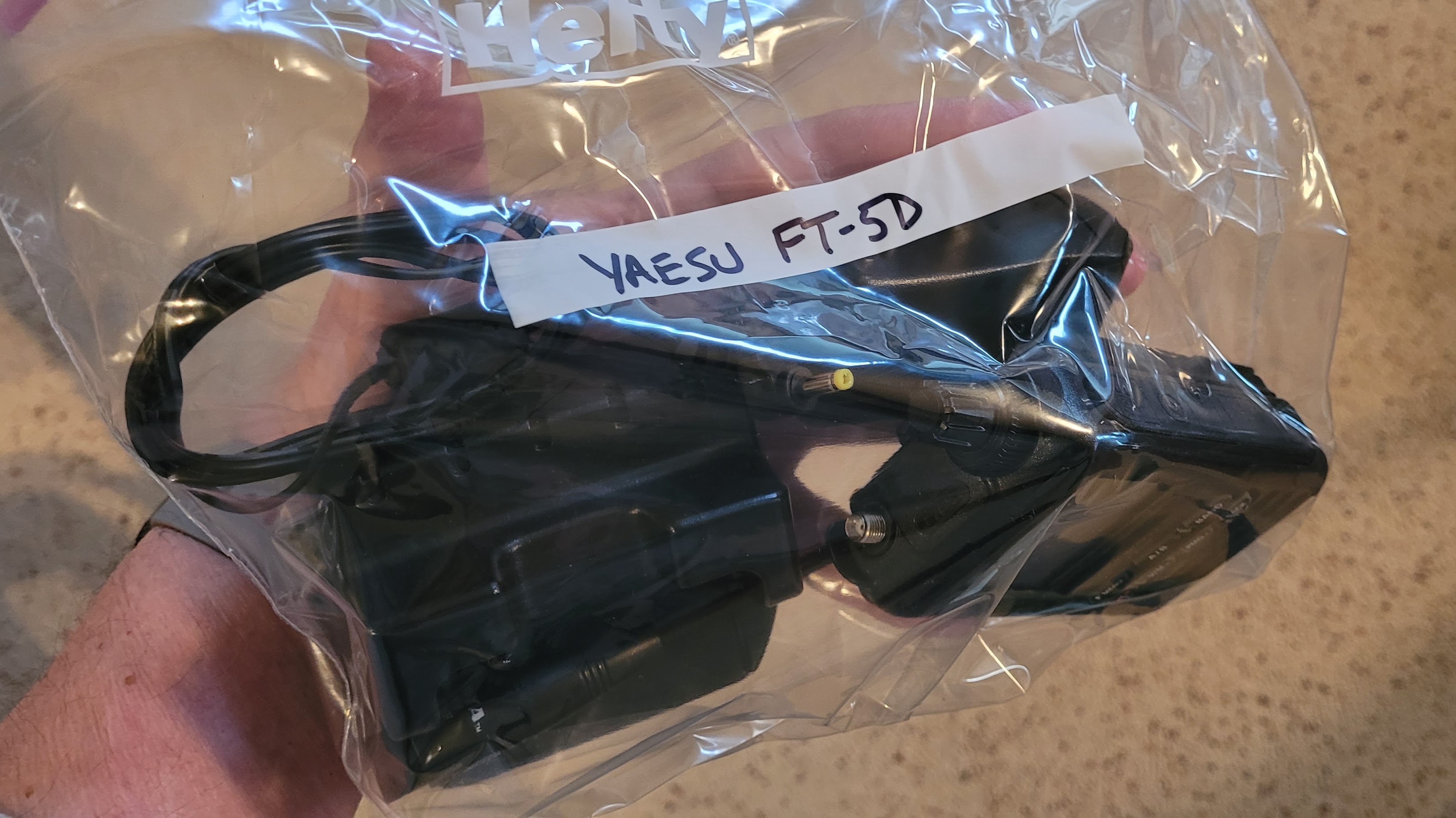 Yaesu FT-5D handheld and parts in a zippered plastic bag