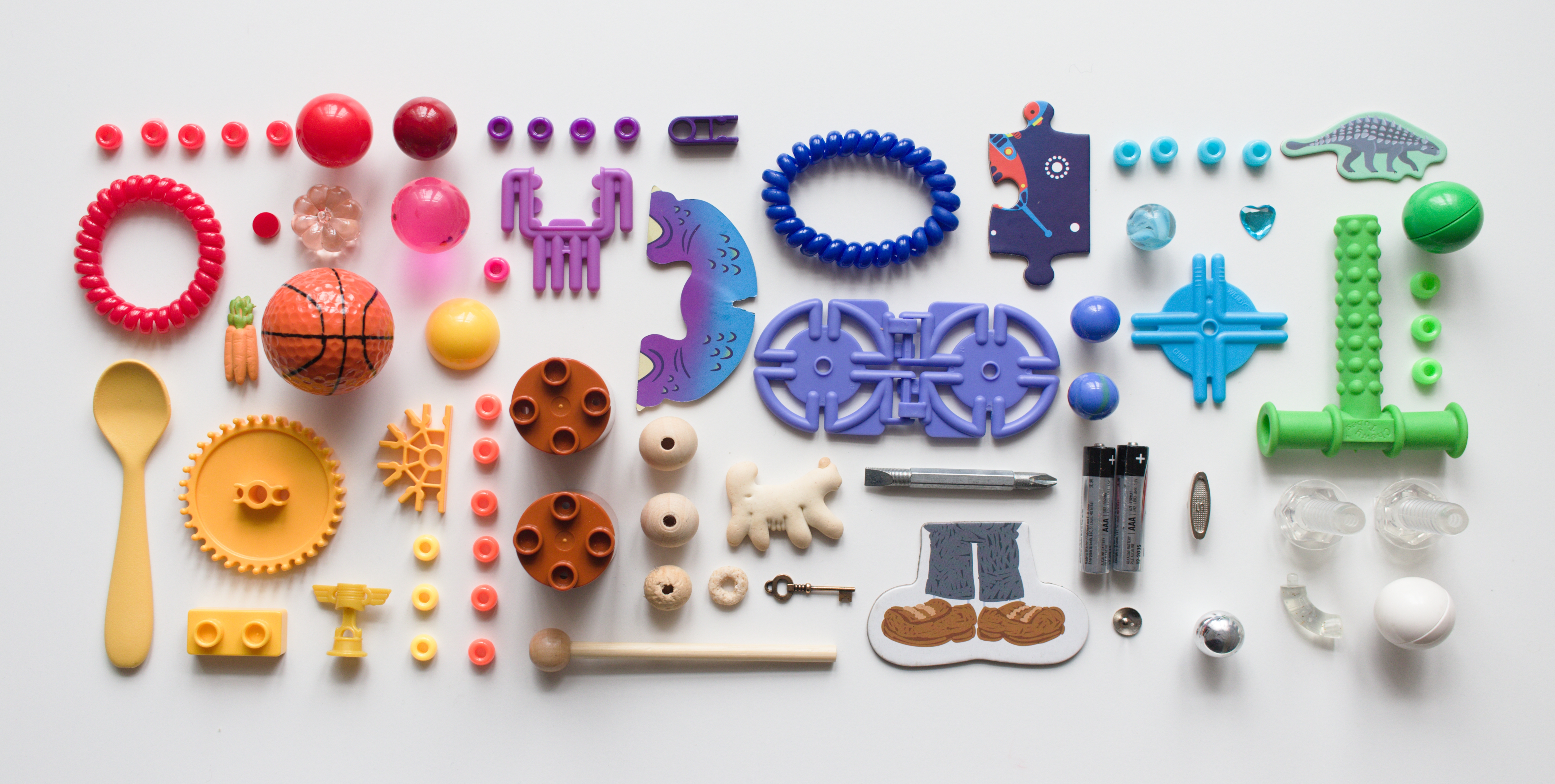 Collection of items from under the couch set out in rainbow order.