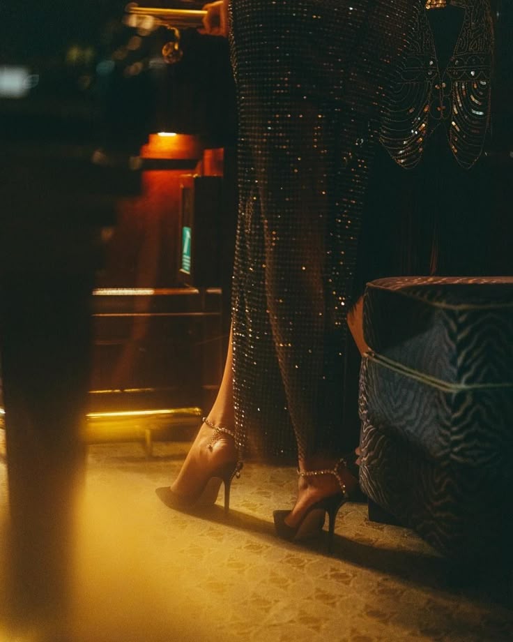 This may contain: a woman in high heels standing next to a table
